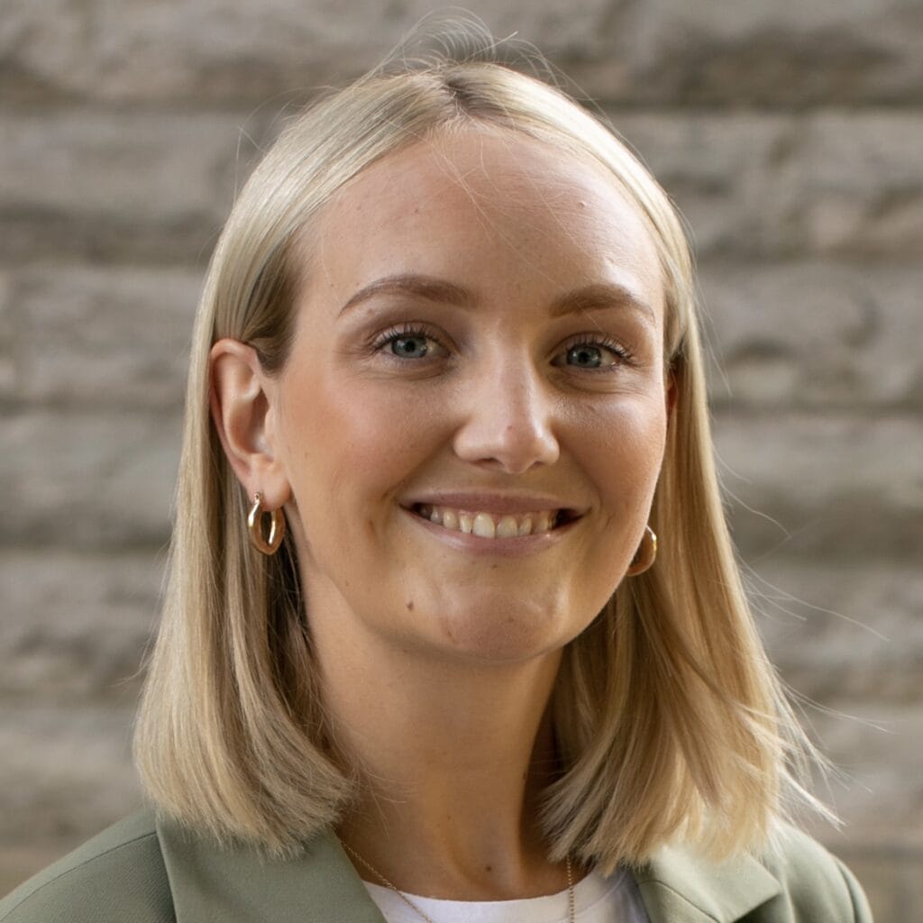 Glad kvinna med blont hår och guldkedjor, professionell porträttbild.